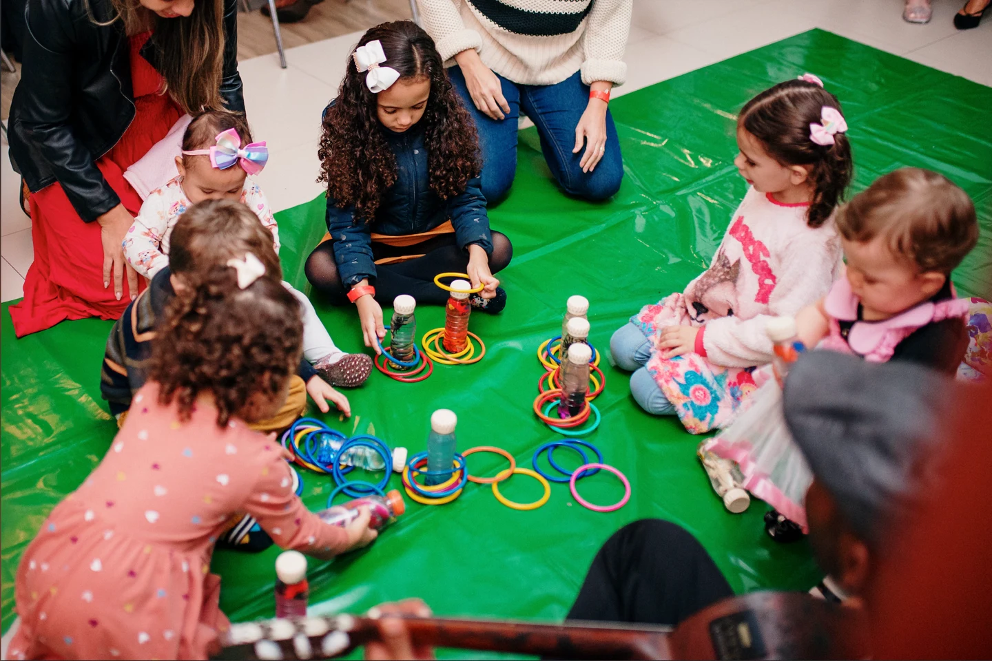 Crianças brincando e aprendendo em tapete verde